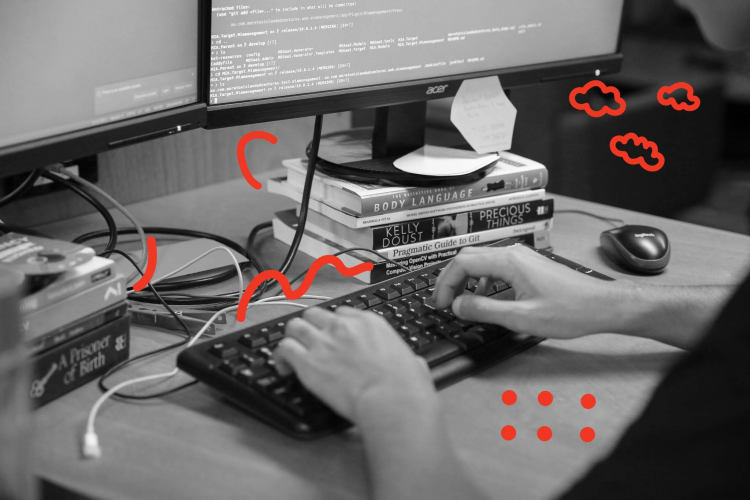 Close up of a mans hands using a keyboard, ther are red doodles around him