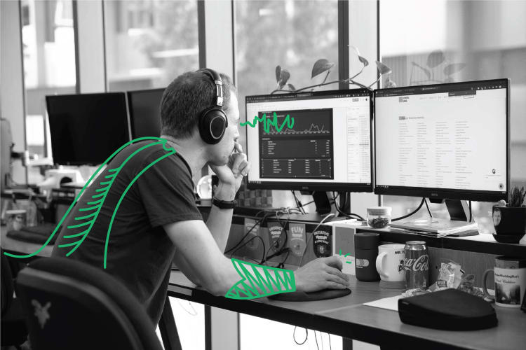 A man using a computer with green doodles digitally added to the photo