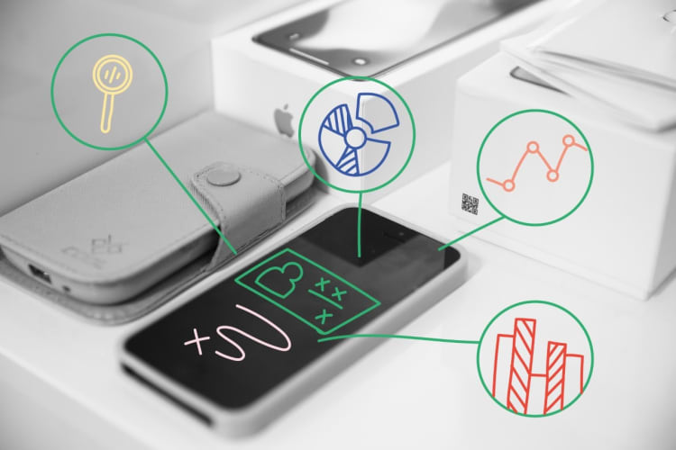 Smartphone on a desk with icons representing data analysis, charts, and graphs, symbolising the use of analytics tools for mobile applications and business insights.