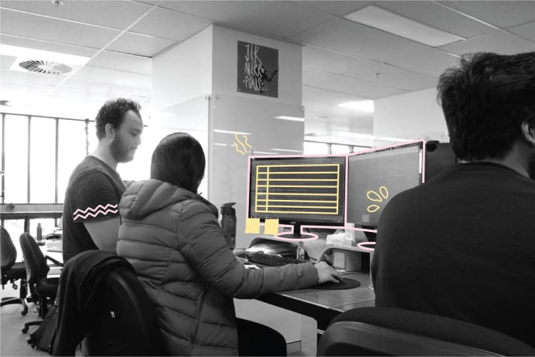 A group of WorkingMouse employees sitting around a computer