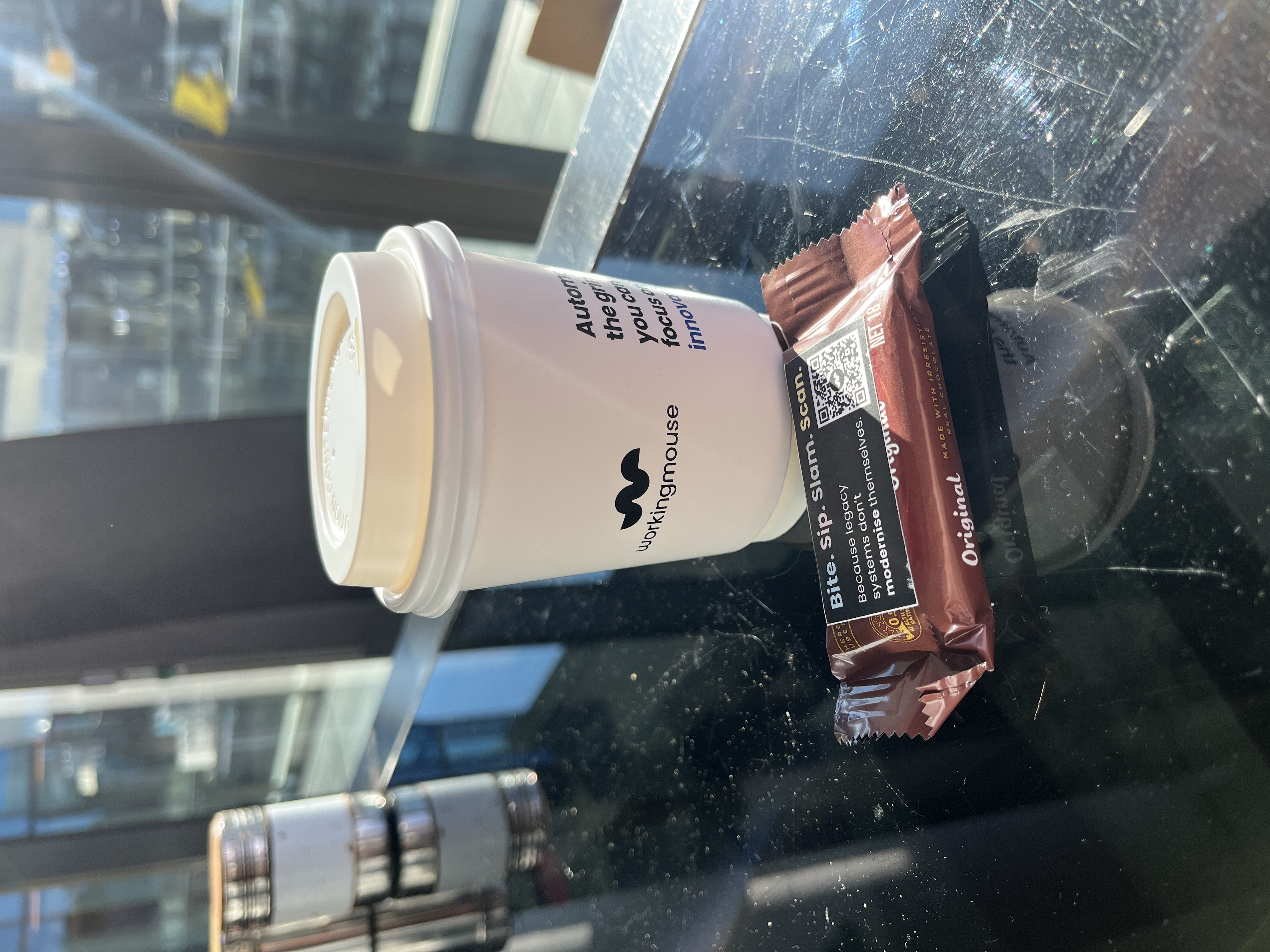 A photo of a coffee cupand a branded timtam